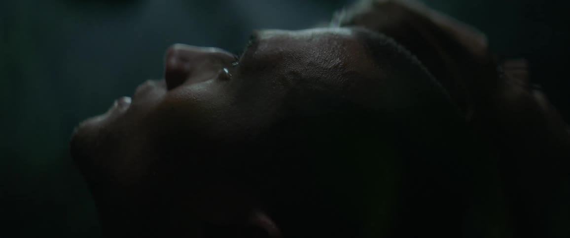 A man looks upward in a dimly lit space