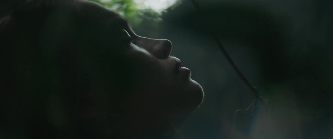 A woman is resting as vines move around her
