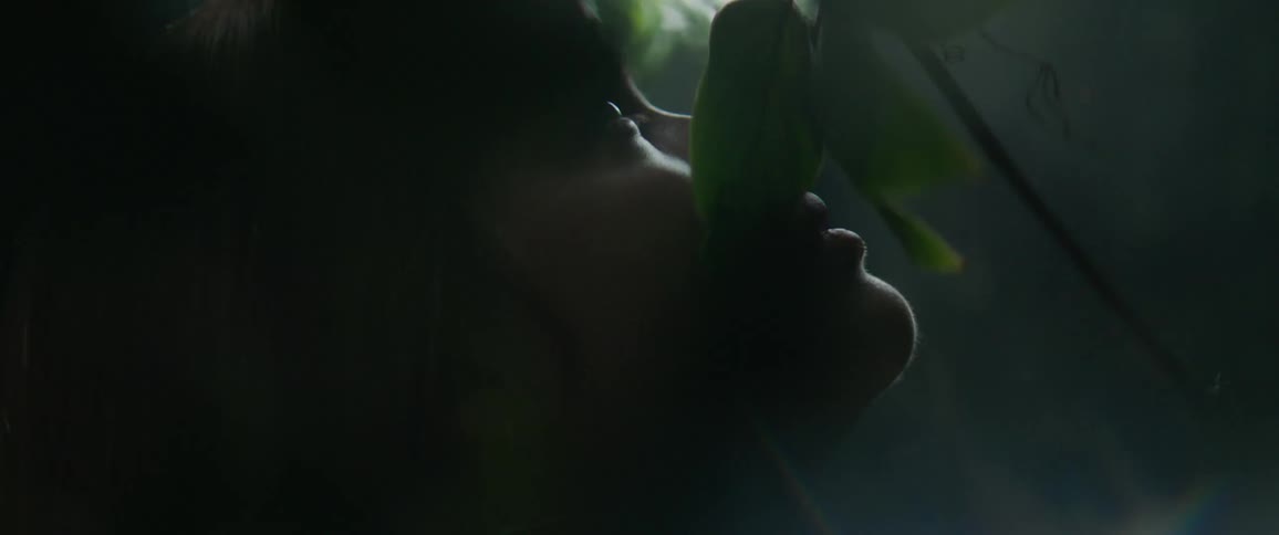 Vines grow around a woman's face