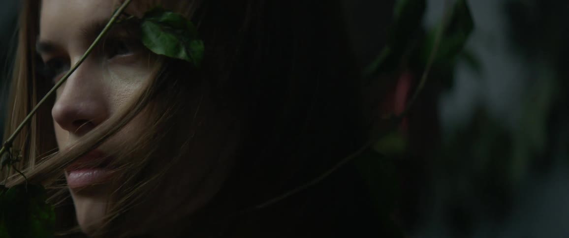 Vines are wrapped around a woman's face