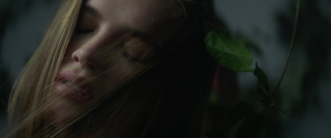 Vines are wrapped around a woman's face