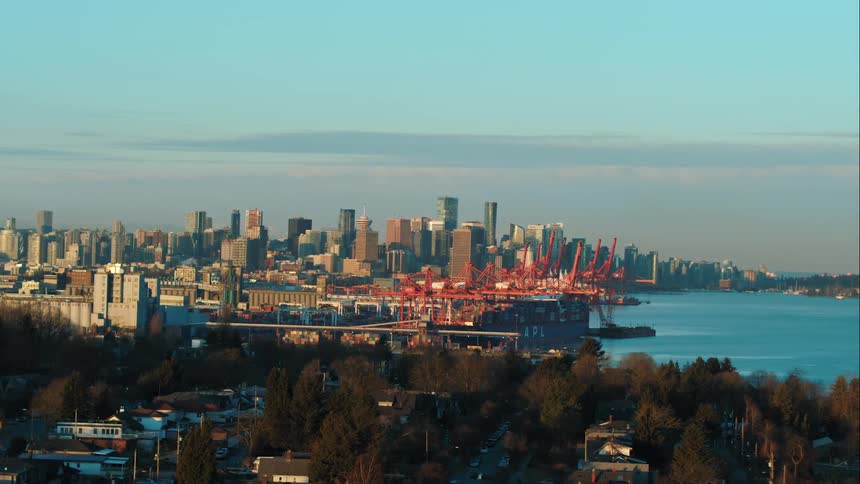 Downtown Vancouver skyline is visible beyond a port