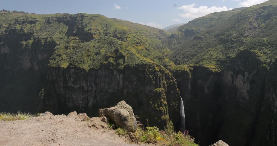 Birds fly over a large chasm