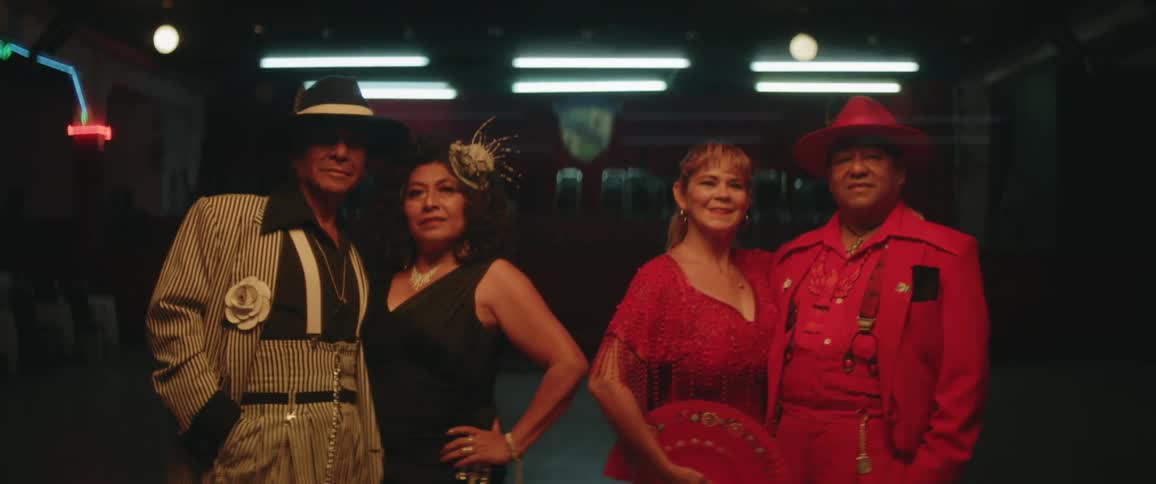 Two couples are dressed up in suits and dresses
