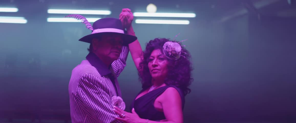 A man and woman dance on a dance floor