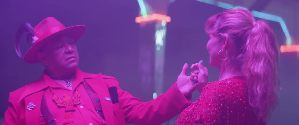 The man is leaning back as he dances with the woman