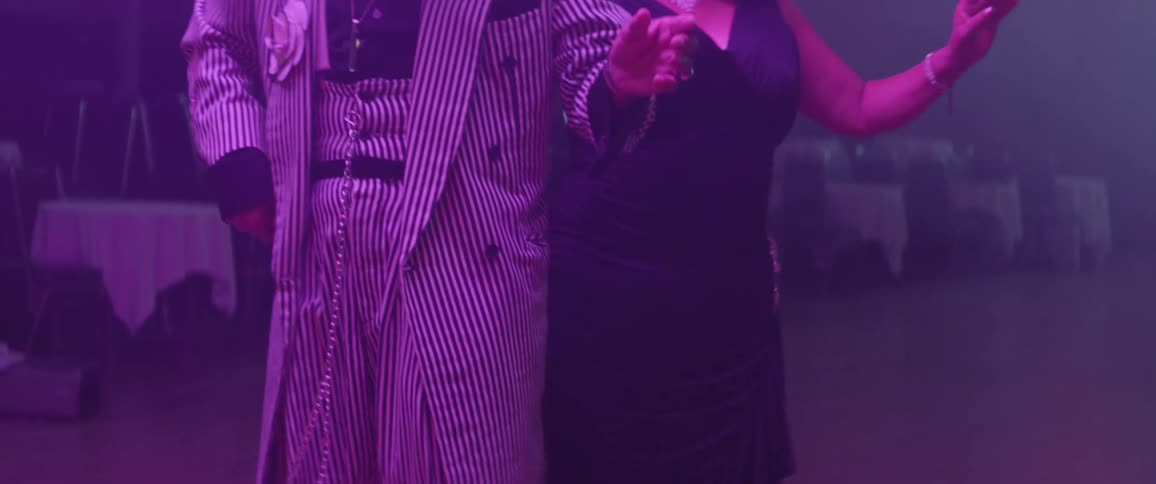 A man and woman dance together spinning around