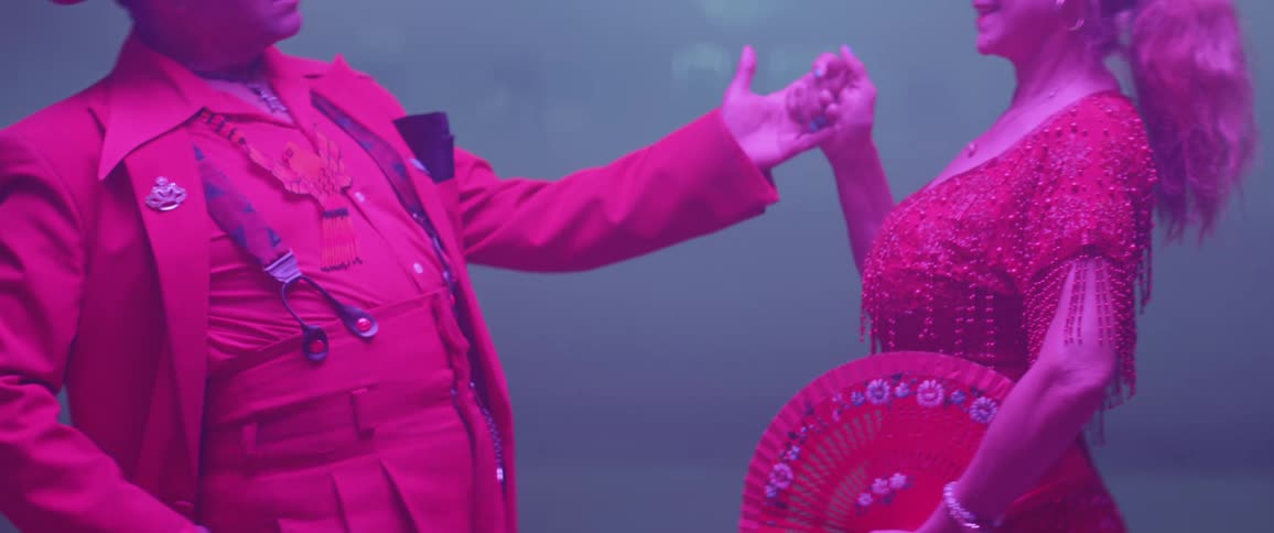 Two people are dancing under bright lights