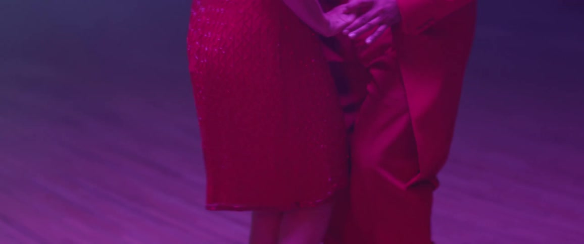 Two people in red dance together on the floor