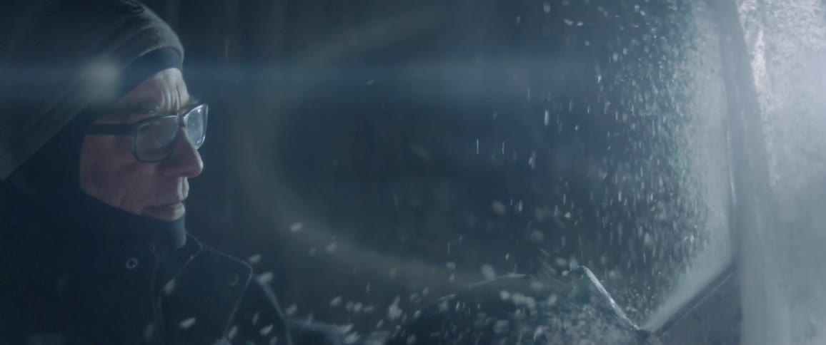 A man is carving ice outside in winter
