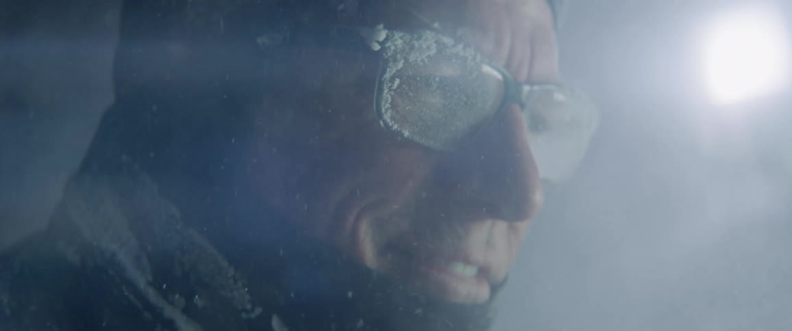 A man carves an ice sculpture outside