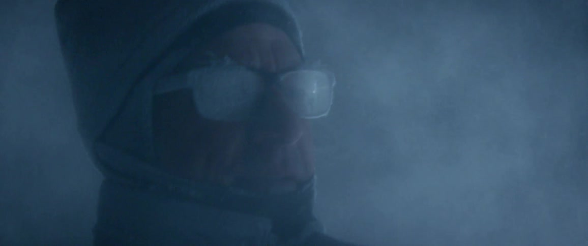 A man works debris flying into his face in the dark