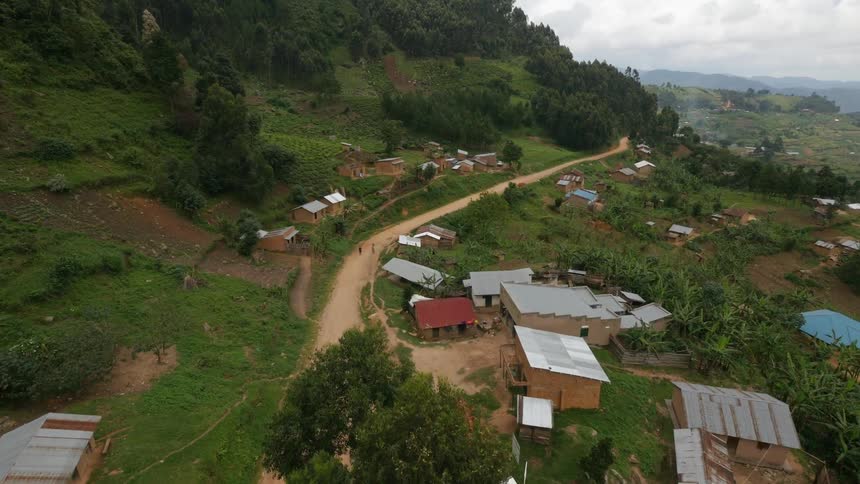 An aerial view of a dirt road and the village surrounding it