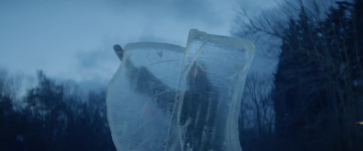 Person saws on a large block of ice with a chainsaw