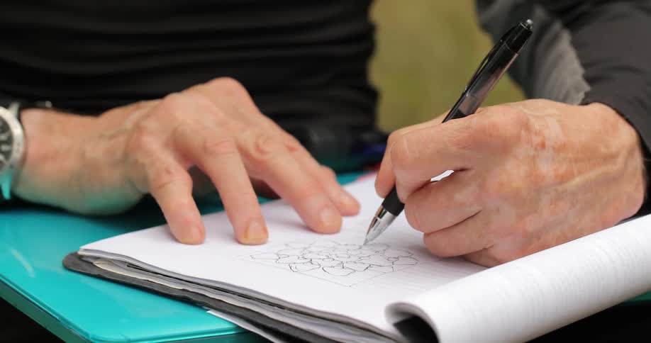 A person is using a pen to write in a book