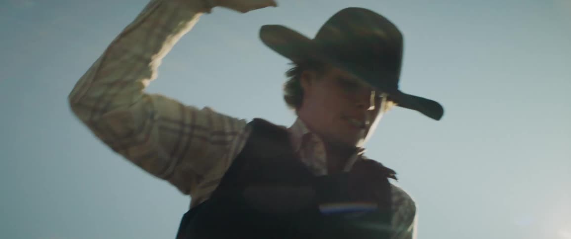 A rodeo cowboy rides and tries to balance himself