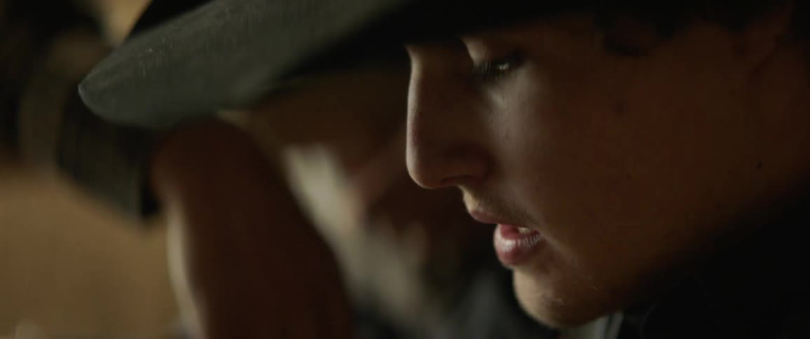 A man in a cowboy hat talks to another leaning over a fence