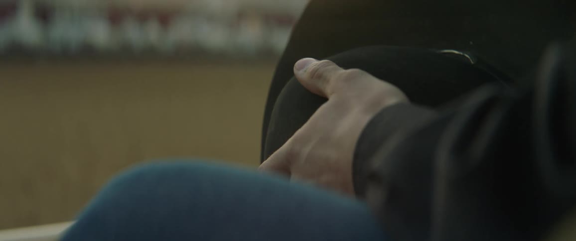 Someone is sitting down holding a cowboy hat in their hands