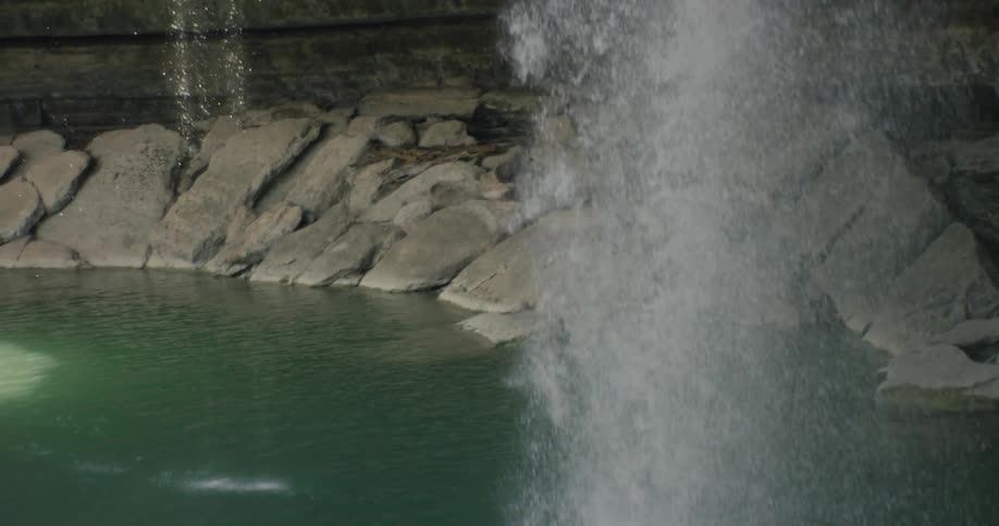 A waterfall pours into a rocky pool