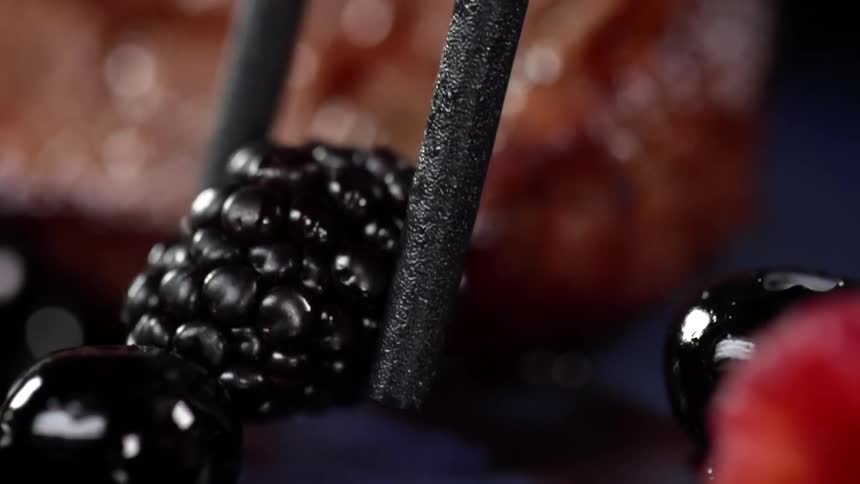 A blackberry being set on a plate