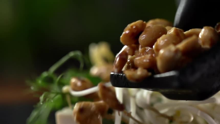 Cooked mushrooms served over sprouted beans