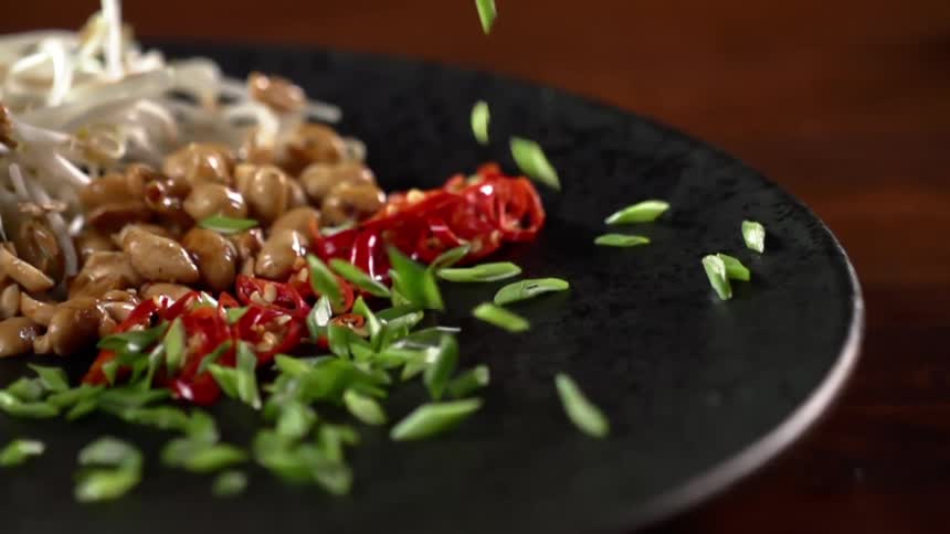 Onions falling on to a plate with other food