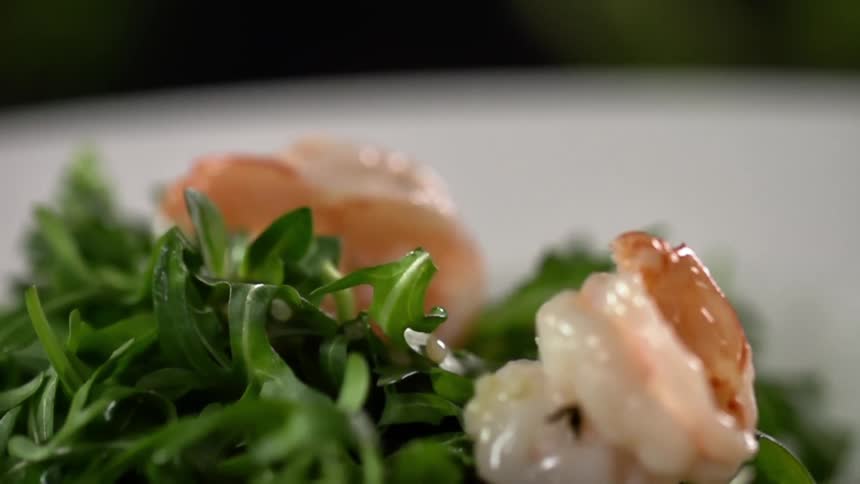 Shrimp drop on a plate filled with greens
