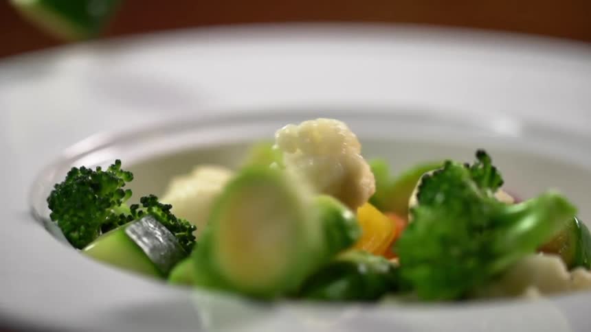 Vegetables falling into a bowl