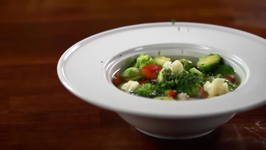 Seasoning falls into a bowl of vegetable soup