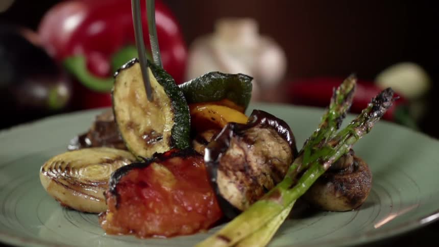 A piece of grilled cucumber is placed on the vegetarian dish