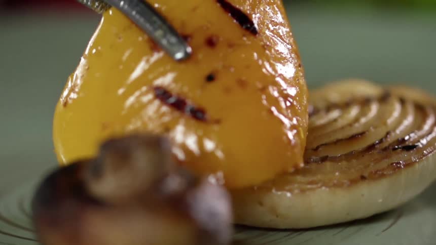 The grilled vegetables are being plated