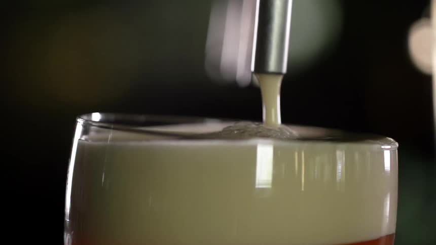 Foam coming out of a beer tap as it is poured in to a glass