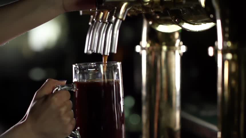 A person pours a beer in a glass