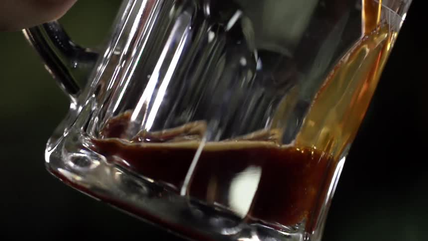Dark beer pouring from the tap into a beer glass