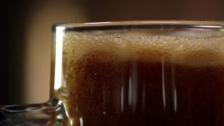 Pouring beer in a glass rising to a foam at the top