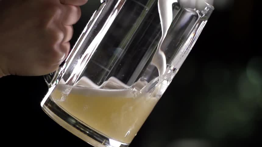 A man fills a glass with beer