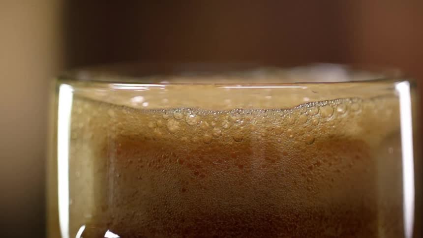 The foam is moving in the beer glass