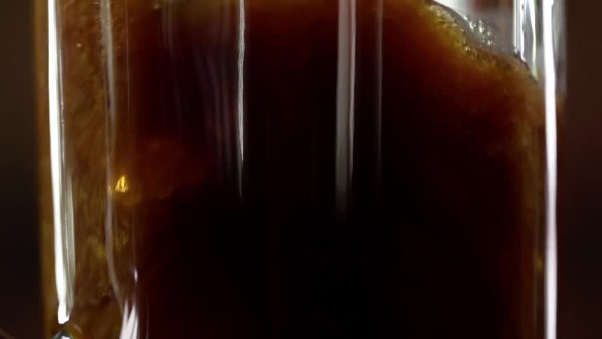 Dark beer bubbling while filling a beer glass