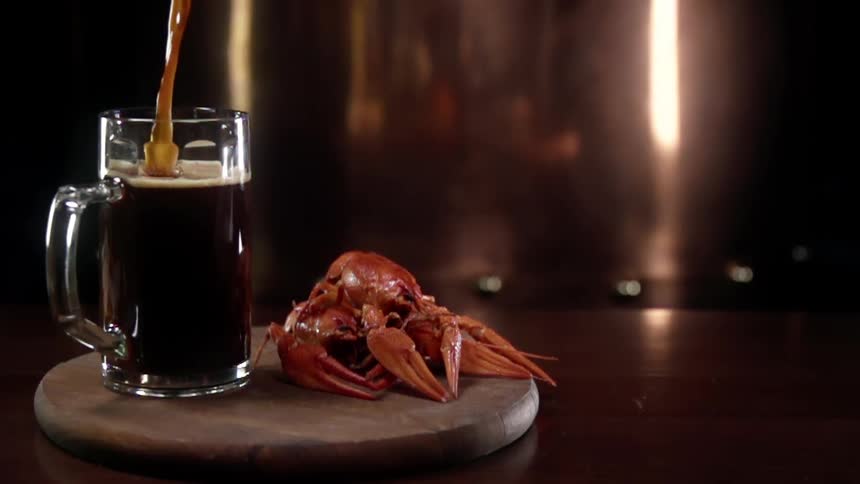 A beverage being poured next to a piece of seafood