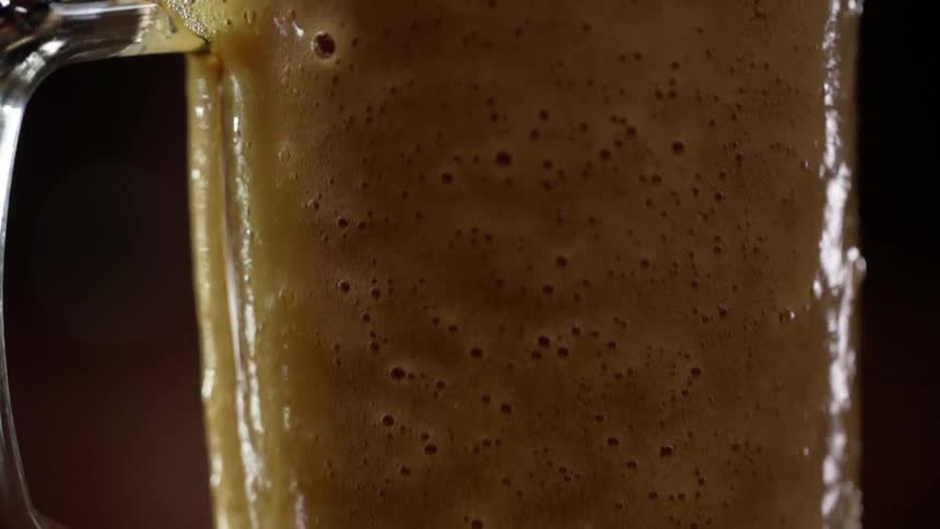 A beer overflowing in a glass