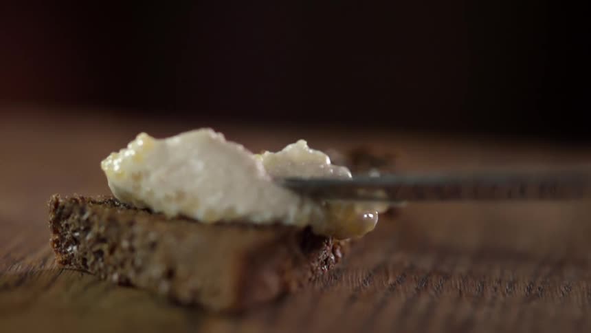 Cream being spread on a baked dessert with a butter knife