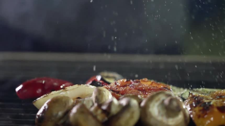 Seasoning is sprinkled on the grilling food