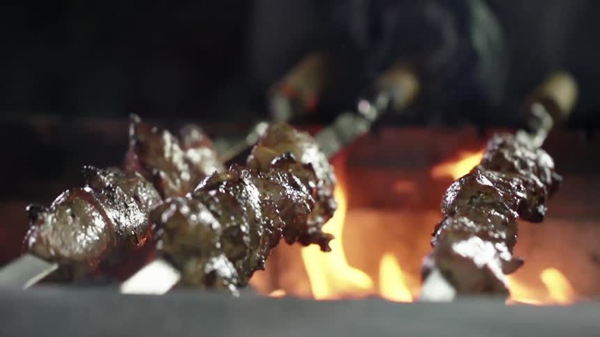 Meat kebabs are cooking on the fire