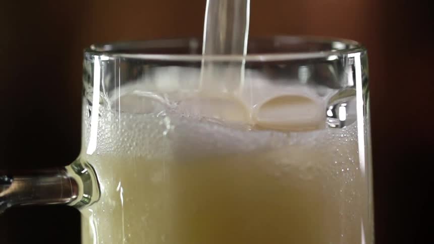 Beer pouring inside a beer glass in a bar