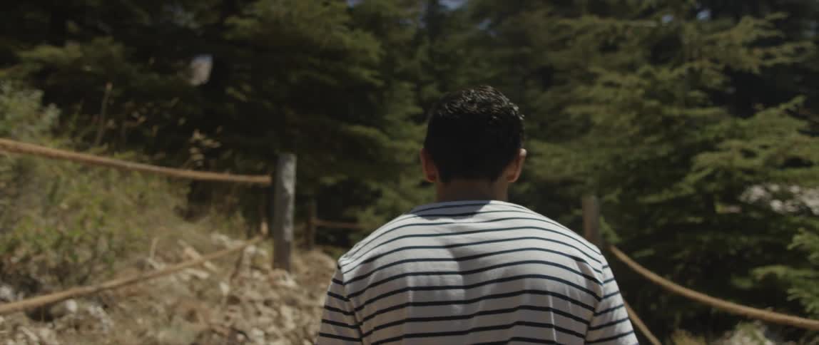A man is walking along a trail on a sunny day