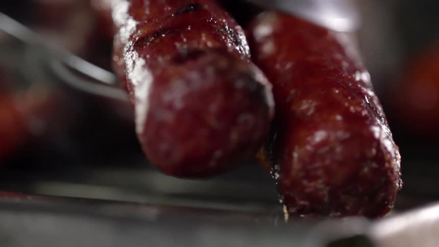 Sausages being set on a grill