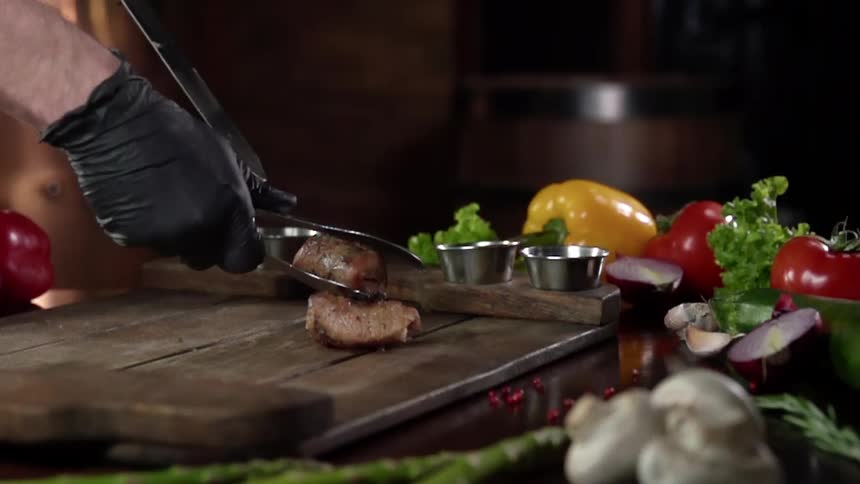 A person places a steak on the cutting board