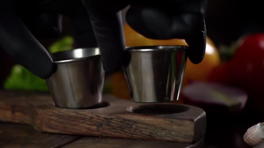 A person puts condiments on a wooden tray as they plate a meal