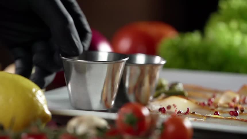 A person puts a metal bowl on a plate