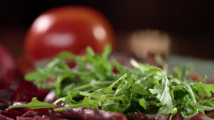 Lettuce falls onto a pile of food on a table
